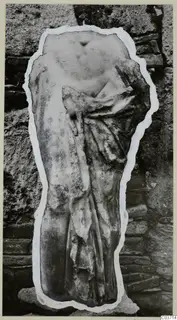 Marble sculpture fragment of a draped torso, cut out and mounted on a card against a stone wall