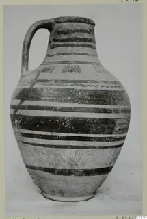 Pottery Bichrome VI-VII jug with a strap handle and dark painted bands on a pale surface