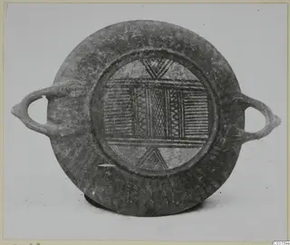 Round shallow vessel with two loop handles, its central panel decorated with bands of horizontal lines, zigzags and cross-hatching