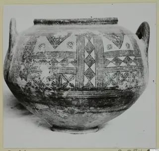 Two-handled painted pottery vessel with hatched geometric decoration, photographed against a light background