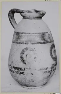 Pottery White Painted IV jug with a loop handle and dark painted bands and circles