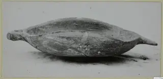 Pottery White Painted III: an elongated, boat-shaped bowl with raised ends, photographed from the side