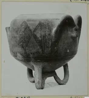 Pottery vessel on three looped legs with dark painted geometric bands and a large loop handle on the right
