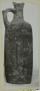 Single-handled pottery vessel with a tall neck, photographed on a mounted card
