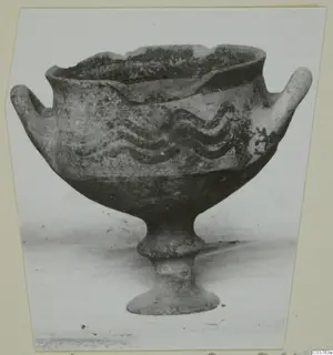 White Painted I bowl on a stem foot, with two side handles and dark wavy painted bands around the body