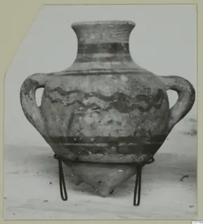 Two-handled pottery amphora with wavy and banded painted decoration, standing on a wire stand