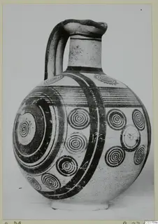 Bichrome IV jug with a strap handle and dark concentric-circle painting, in three-quarter view