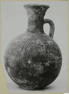 Globular jug with a tall flaring neck and a single loop handle, photographed on a card mount
