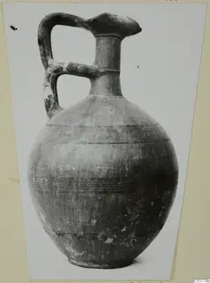 Round-bodied jug with a strap handle and horizontal bands of lines, recorded as Black-on-Red I-III