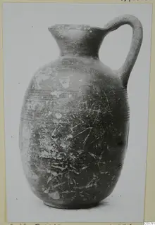 Single-handled jug with a high neck and rounded body, photographed against a plain background.