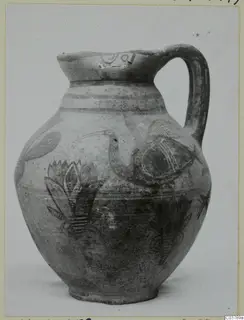 Pottery Bichrome IV jug with a painted bird and plant motifs in dark on a pale surface