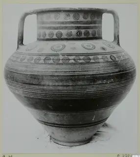 Two-handled painted pottery jar with bands of concentric circles and horizontal stripes, photographed against a plain background.