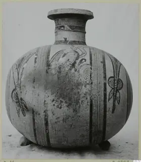 Jug with a flat-rimmed mouth, painted vertical bands and stylised plant motifs, shown from the front against a plain backdrop