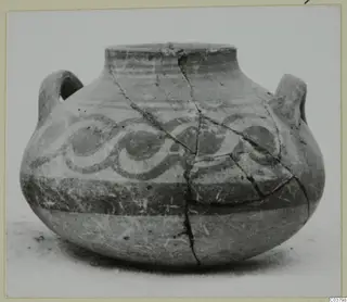 Painted pottery jug with two handles and spiral bands, from the Bichrome series, shown on a plain surface.