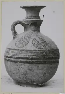 White Painted IV vessel with a flaring neck, single loop handle and painted spiral motifs on the shoulder