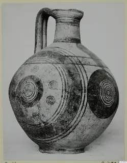 Jug with a strap handle and dark concentric circles and bands painted on its body