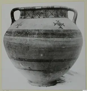 Two-handled pottery jar with painted bands and a cross-hatched rim band, photographed against a plain background.