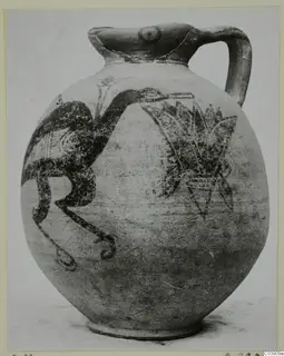 Bichrome IV jug with a painted bird and a spray of leaves, photographed on a light card mount