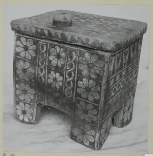 Painted pottery box with lid, round knob and four short feet, decorated with white flower motifs and bands