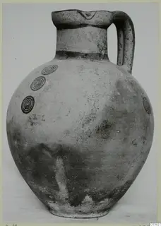 Pottery White Painted IV jug with a single loop handle and dark concentric circle motifs on the shoulder