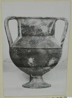 Two-handled amphora-crater with concentric circles and dark horizontal bands, on a pedestal foot.