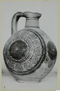 Bichrome IV jug with a strap handle, its pale body painted with dark concentric circles and bands