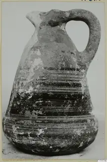 Pottery jug with a single loop handle and banded painted decoration, shown on a plain background