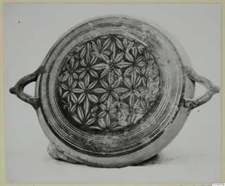 Two-handled plate-jug with concentric bands on the rim and a central field of star-shaped rosettes