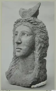 Carved stone head with a wavy hairstyle and a broken projection on top, from Soli