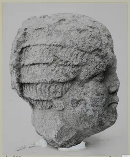 Stone head from Soli, shown in profile facing right, with a ridged headdress.
