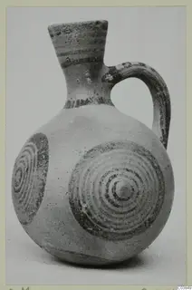 Pottery jug with a flaring neck, one handle and dark concentric circle decoration on the body