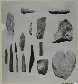 Flint, obsidian, stone and bone tools from Petra tou Limniti, laid out in rows on a grey background