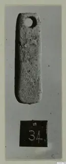 Small elongated pierced pendant, photographed upright on grey card with a number label, from Ayios Iakovos