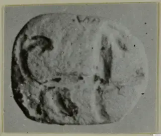 Engraved seal or gem with a rounded-rectangular face, photographed against a plain grey ground