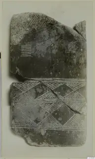 Broken flat fragment with incised chevron and hatched bands, photographed on a mount