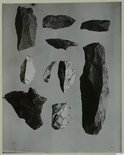 Flaked stone tools and fragments from Kythrea, laid out together on a grey background.