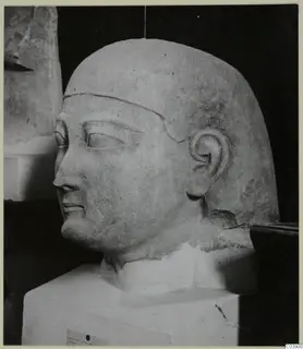 Limestone Cypro-Egyptian sculpture of a head and bust, shown on a white block base