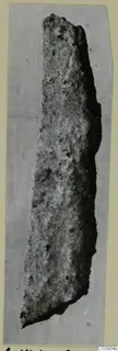 Long, narrow corroded iron object from Amathus tombs, shown on a mounted photograph card
