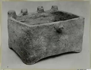 Rectangular terracotta chest with an open top, rounded knobs along the rim and a small knob on one side