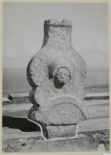 Limestone sculpture from Vouni (V. 289) with a broken top and a round, face-like relief on the front