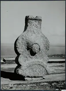 Limestone sculpture from Vouni, a weathered upright figure with a rounded face-like boss, standing on a stone base