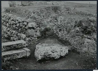 Excavated stone steps and a large stone block beside a rubble wall at the theatre at Soli