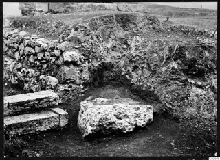 Excavated stone steps and a large stone block at the theatre at Soli, with a cut earth face behind.