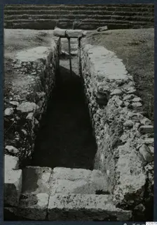 Narrow excavated cutting with stone-faced walls and steps at the theatre at Soli