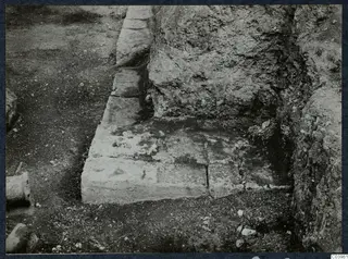 Excavated stone steps against a rock-cut bank at the theatre at Soli, with a rounded stone piece at the left edge.