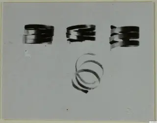 Three coiled spiral rings in a row above a single open spiral, on a plain grey background.