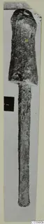Corroded bronze tool with a broad socketed head and a long tapering shank, from the Vrysi tou Barba tombs at Lapithos