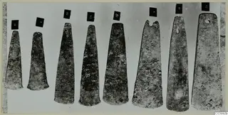Eight flat bronze blades laid in a row, with number labels, from Lapithos Tomb 322A