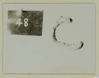 Corroded C-shaped metal object beside a number label reading 48, from Lapithos Tomb 311 A