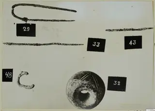 Bronze tools, lead and small finds from Lapithos Tomb 311 A, with number labels, on a pale background.